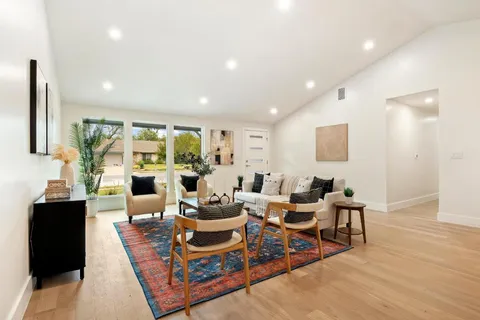 a living room with furniture potted plant and a large window