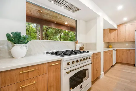 a kitchen with a stove and white cabinets