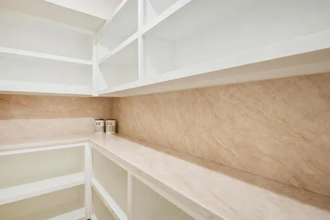 a view of a kitchen with white cabinets and a window