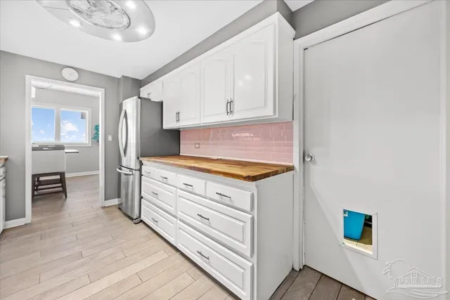 a kitchen with stainless steel appliances a stove oven a sink dishwasher and a refrigerator with wooden floor