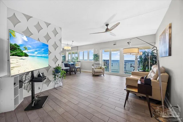 a living room with furniture wooden floor and a floor to ceiling window