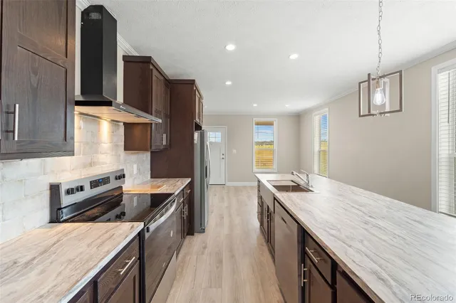 a kitchen with stainless steel appliances granite countertop a kitchen island a stove and a sink