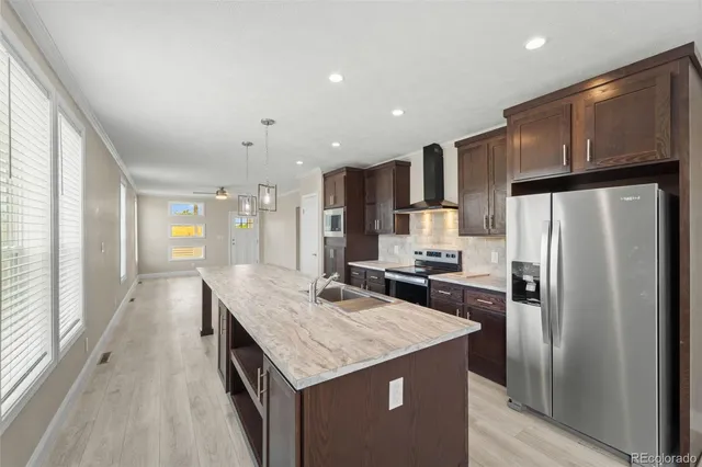 a kitchen with kitchen island granite countertop a sink and refrigerator