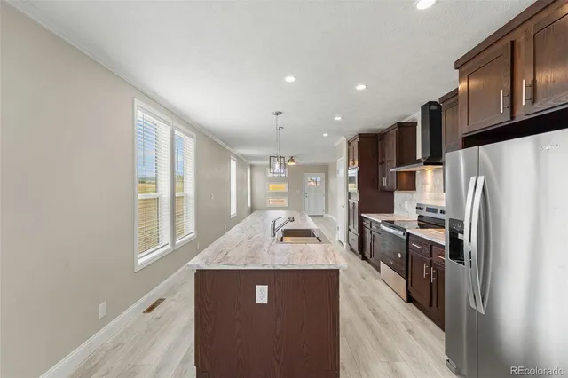 a kitchen with granite countertop kitchen island stainless steel appliances a refrigerator a sink a stove a microwave a sink and cabinets