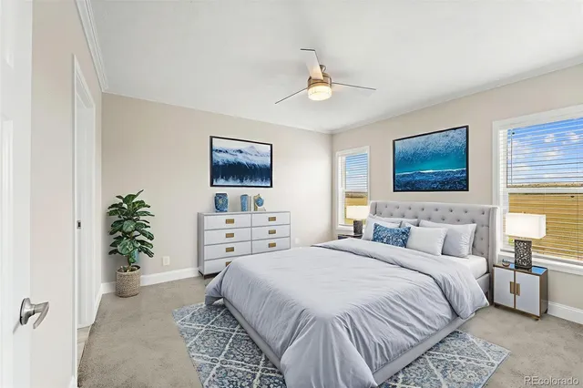 a bedroom with a large bed a couch and potted plant