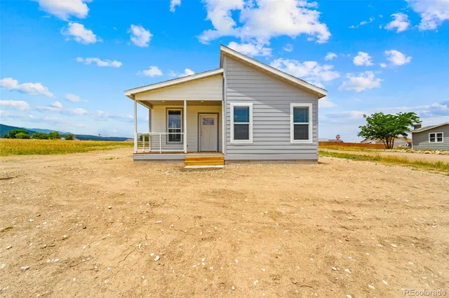 a front view of house with yard and ocean view