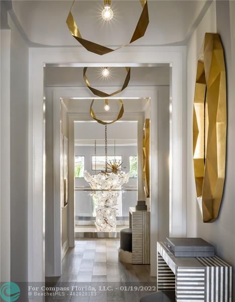91 Compass Lane Fort Lauderdale, FL 33308 - Photo 54 of 59 a room with wooden floor and a chandelier