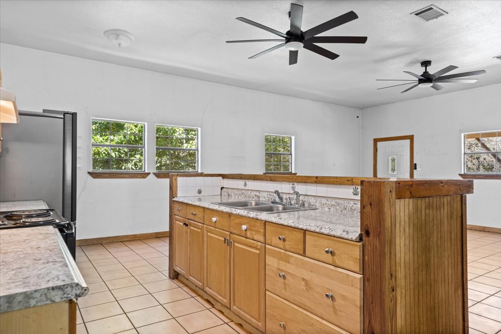 555 Harmon Hills Road, Unit A Dripping Springs, TX 78620 - Photo 15 of 29 Functional kitchen with ample cabinet space and easy-care tile flooring.