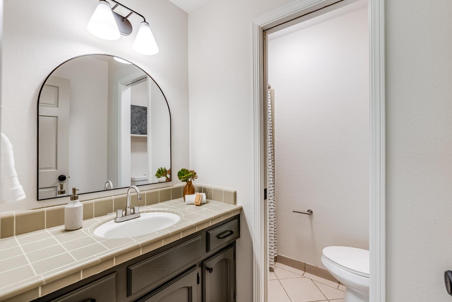 140 Echo Ridge Lane Soquel, CA 95073 - Photo 36 of 50 a bathroom with a granite countertop sink a toilet and a mirror
