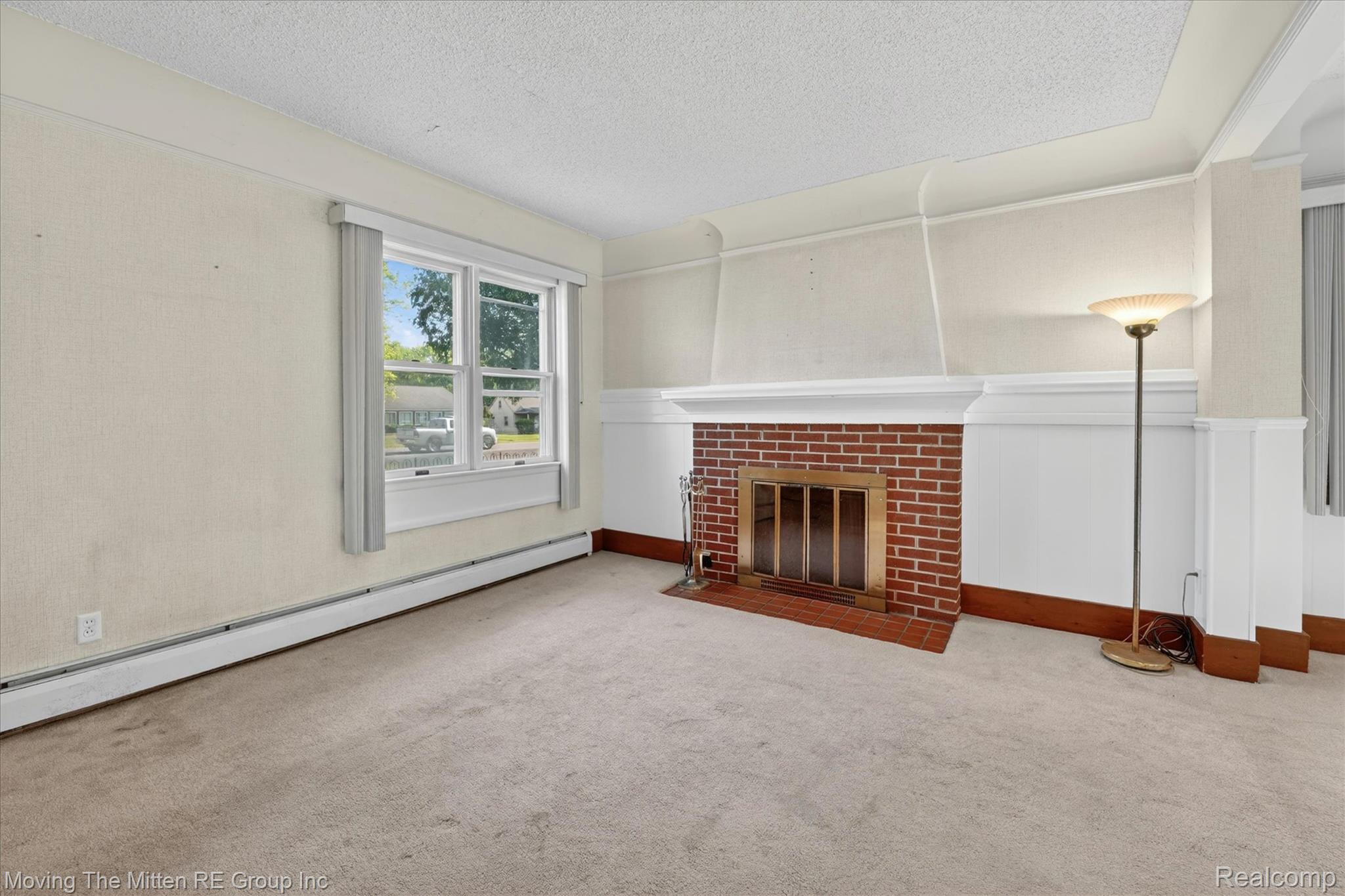25505 Wick Road Taylor, MI 48180 - Photo 7 of 68 Unfurnished living room with baseboard heating, carpet, a fireplace, wainscoting, and a textured ceiling