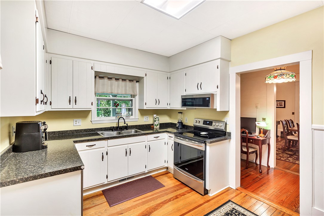 205 West Mauldin Street Walhalla, SC 29691 - Photo 12 of 43 A cheerful kitchen featuring rich hardwood flooring and sleek stainless steel appliances awaits.