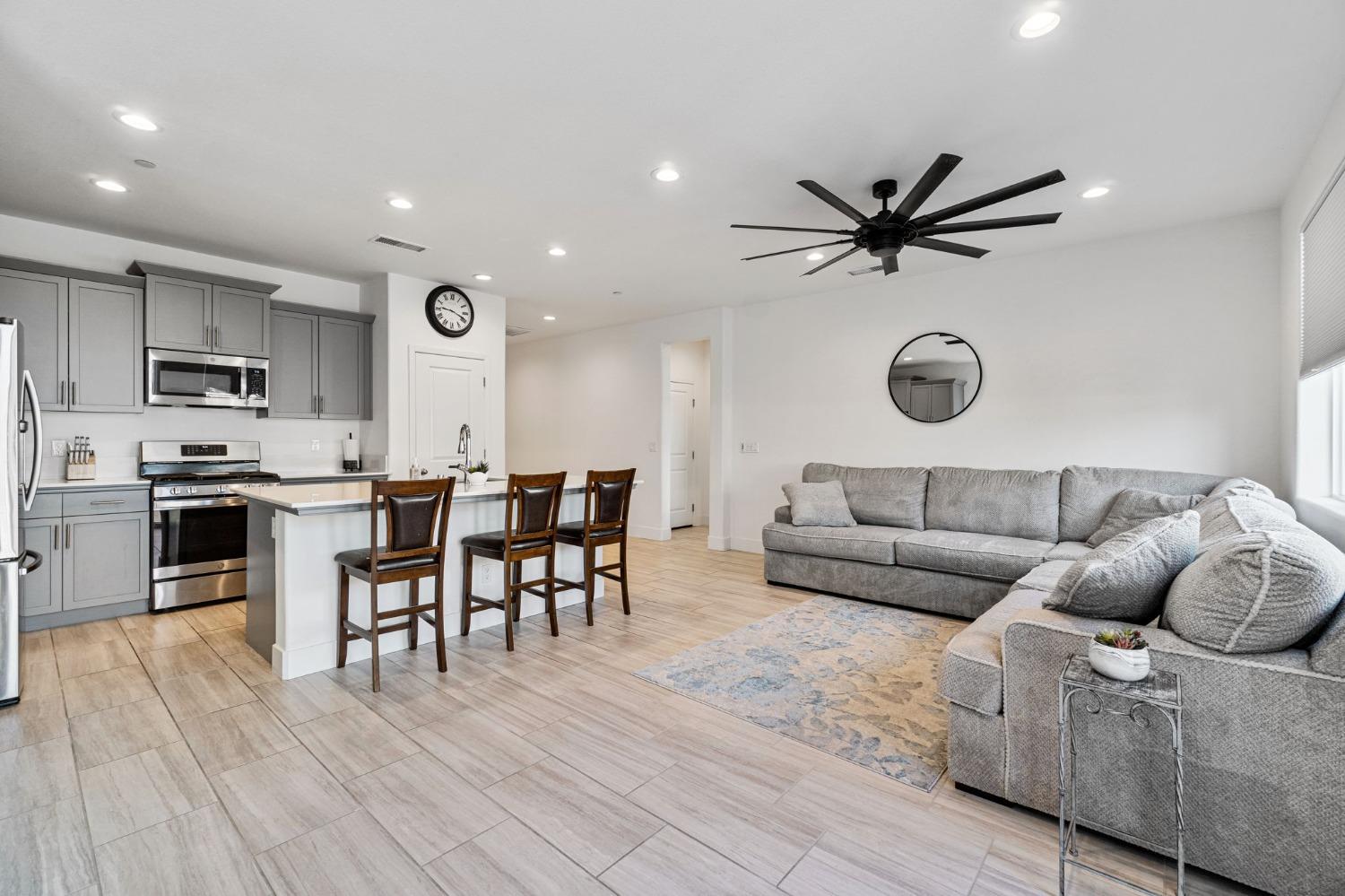 4218 Oak Knoll Road Madera, CA 93636 - Photo 6 of 37 a living room kitchen with a dining table wooden floor and a fireplace