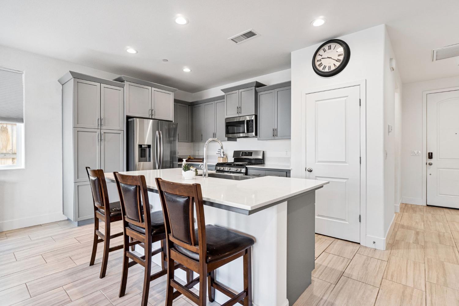 4218 Oak Knoll Road Madera, CA 93636 - Photo 9 of 37 a kitchen with stainless steel appliances a stove a refrigerator a dining table and chairs