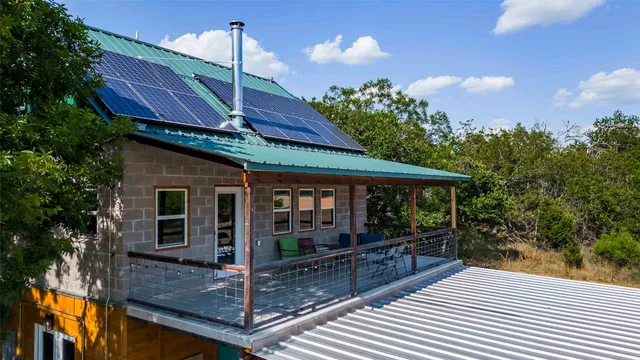 an aerial view of a house with swimming pool and large trees