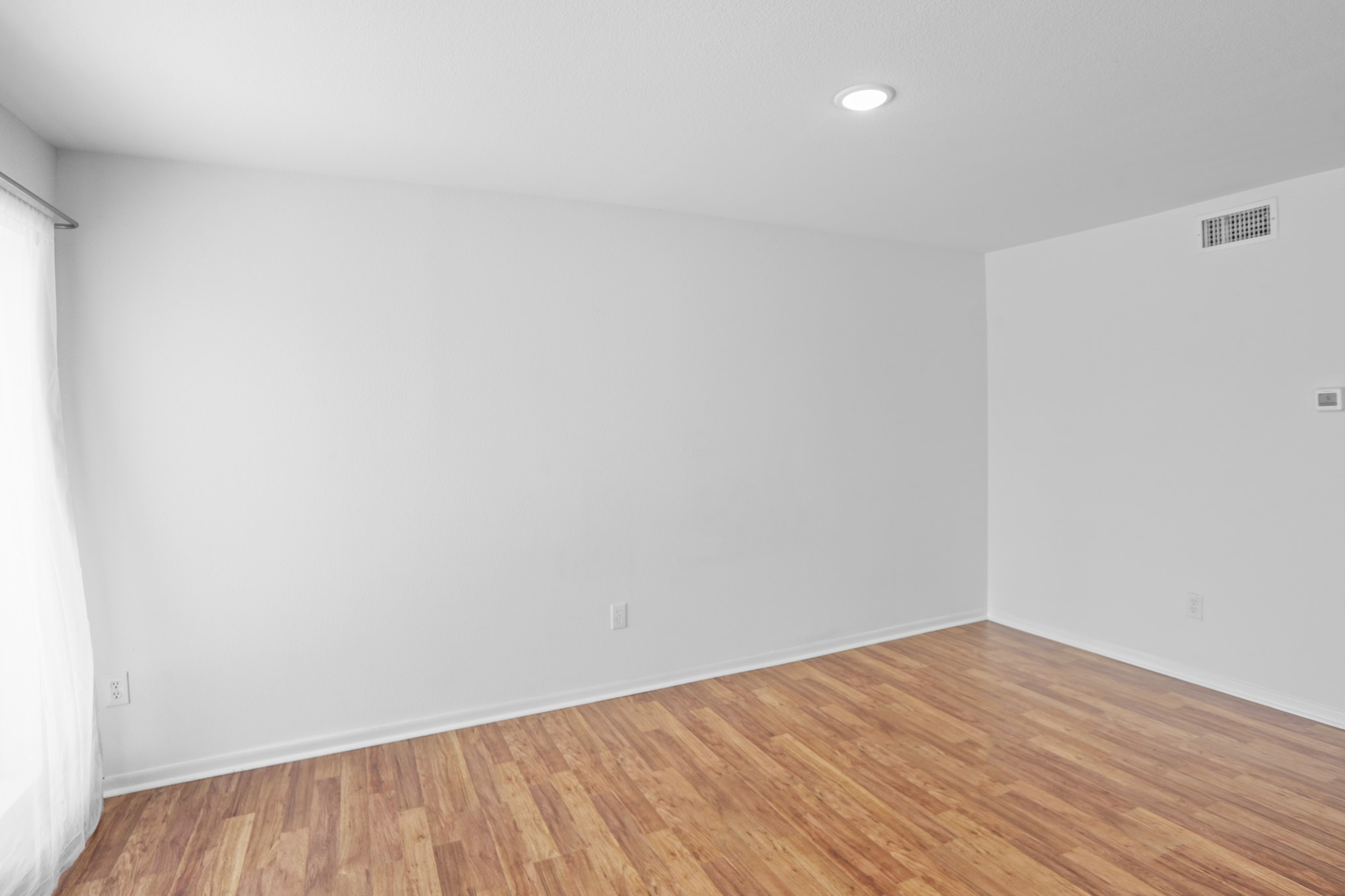 1408 Hughes Street, Unit 4 Houston, TX 77023 - Photo 18 of 27 Another view of the living space with large picture window. Notice the central A/C vent and digital thermostat.