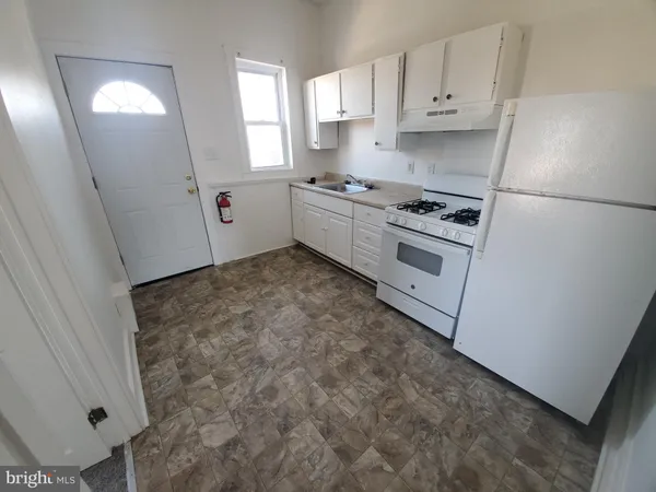 a kitchen with white cabinets and white appliances