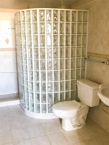 a bathroom with a toilet a sink a mirror and a shower