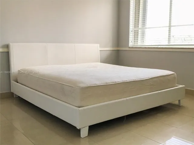 a bedroom with a bed and window