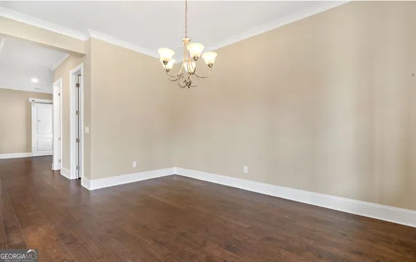 a view of an empty room with kitchen view and a window
