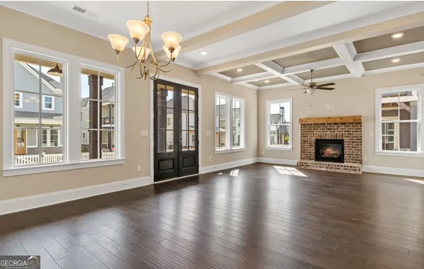 an empty room with wooden floor and chandelier
