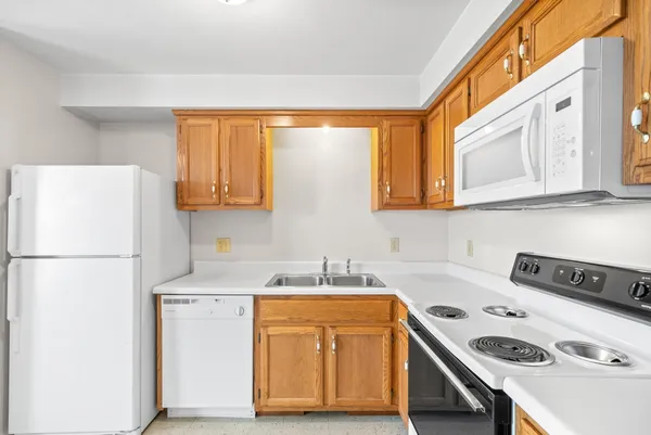 a kitchen with a sink a stove a refrigerator and cabinets