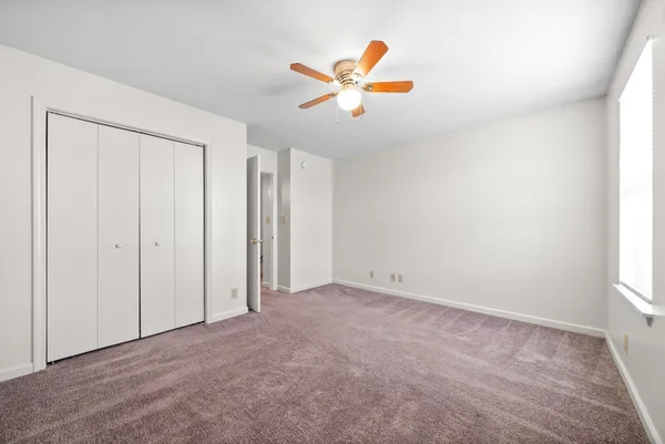 a view of a livingroom with a ceiling fan and window
