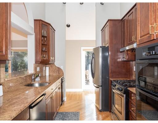 818 Long Pond Road Plymouth, MA 02360 - Photo 16 of 30 a kitchen with stainless steel appliances granite countertop a refrigerator a stove and a sink with wooden cabinets