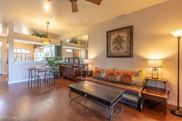 a living room with furniture a dining table and chairs with wooden floor