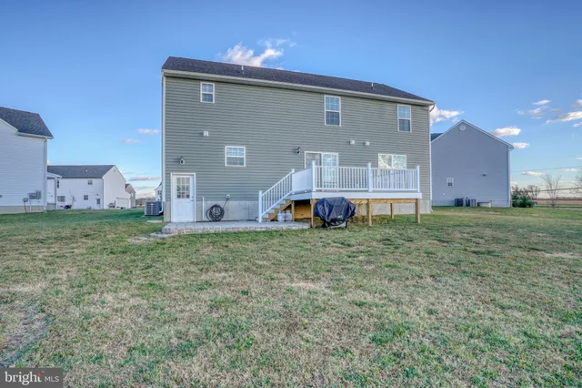 a kitchen with stainless steel appliances kitchen island granite countertop a sink dishwasher and white cabinets with wooden floor