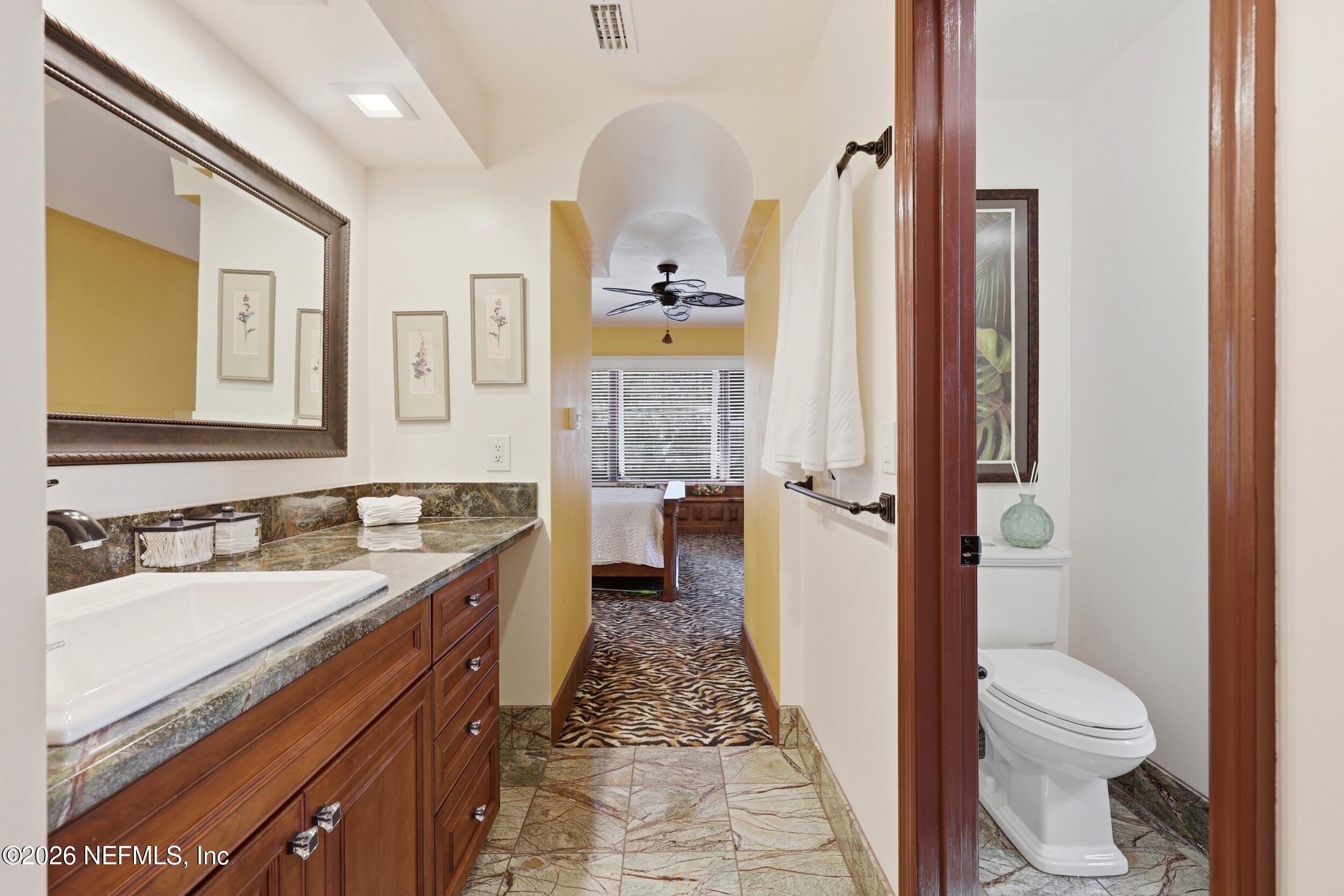 10 Lydia Lane St. Augustine, FL 32080 - Photo 33 of 119 a bathroom with a granite countertop sink a mirror a toilet and a shower