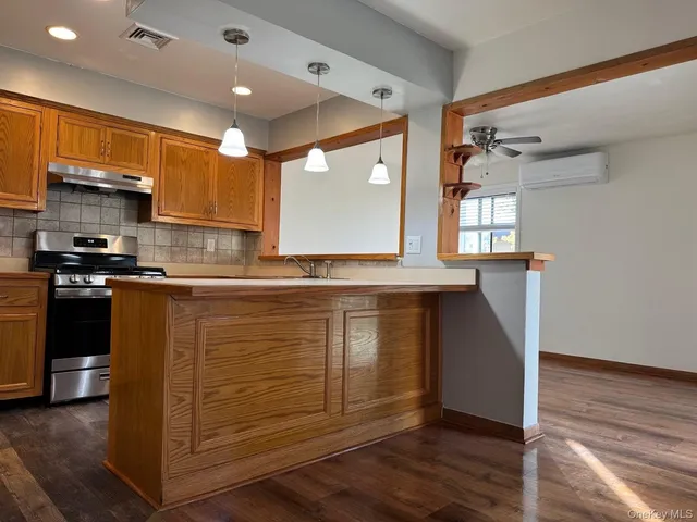 a kitchen with kitchen island granite countertop a sink cabinets and stainless steel appliances