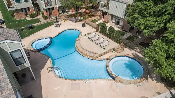 an aerial view of a house with swimming pool and outdoor seating