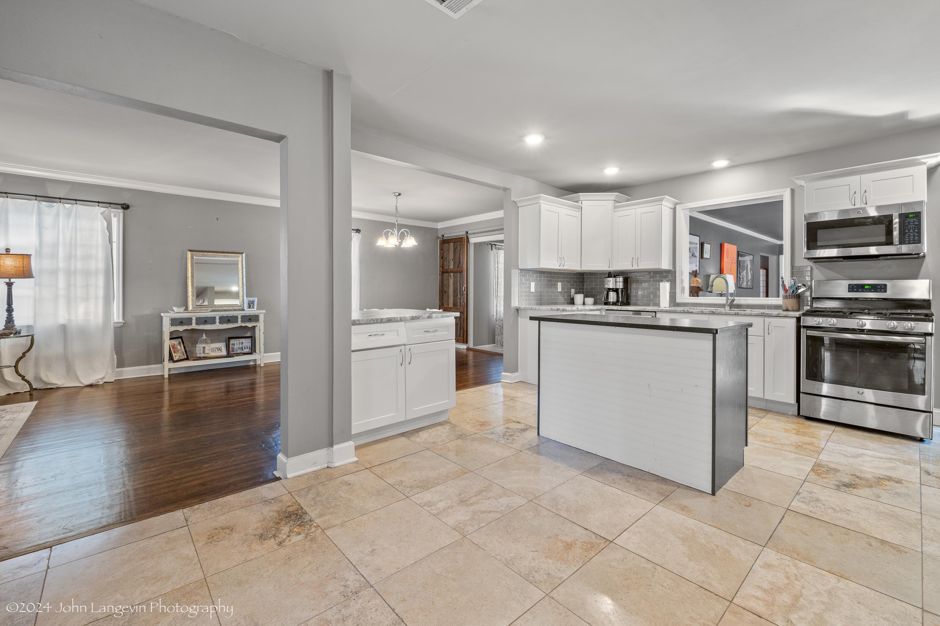 3381 Walnut Grove Road Memphis, TN 38111 - Photo 11 of 25 a kitchen with stainless steel appliances granite countertop a refrigerator oven a sink dishwasher and white cabinets with wooden floor