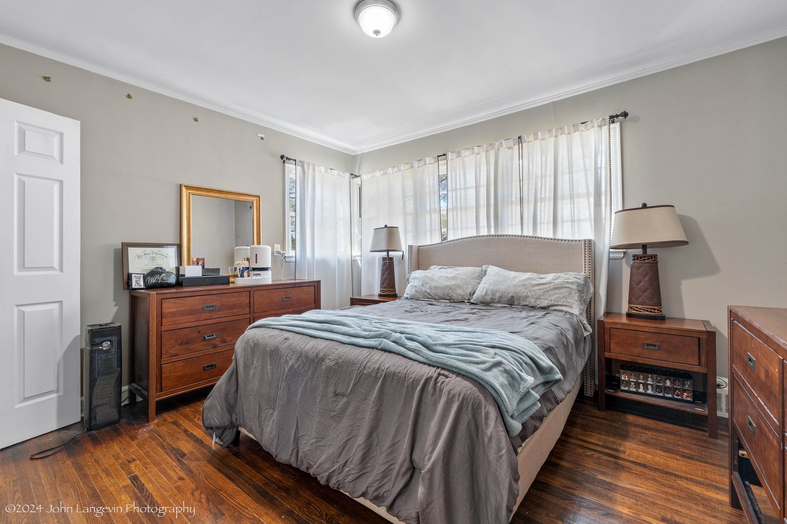 3381 Walnut Grove Road Memphis, TN 38111 - Photo 6 of 25 a bedroom with a bed and a dresser with wooden floor