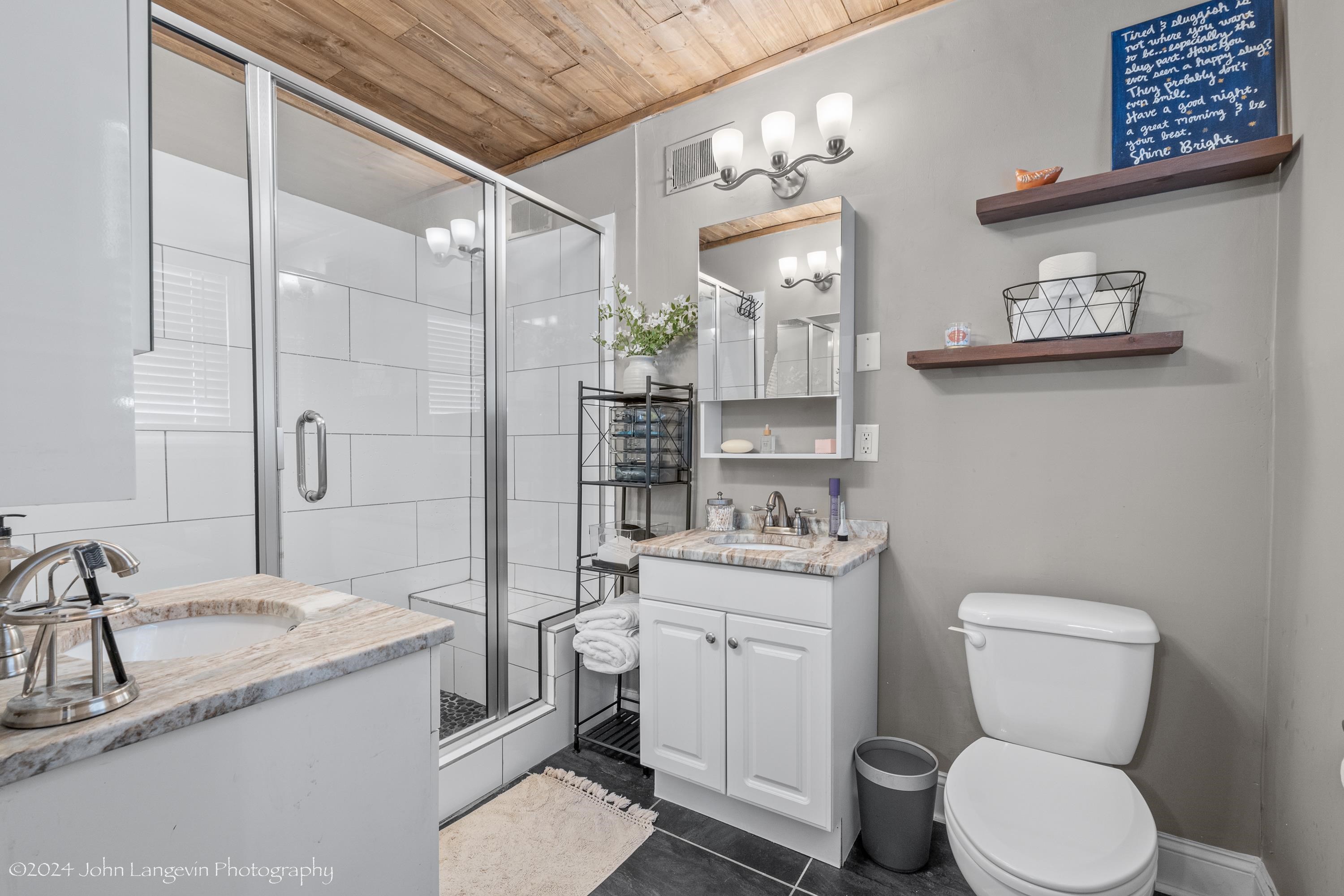 3381 Walnut Grove Road Memphis, TN 38111 - Photo 10 of 25 a bathroom with a granite countertop toilet a sink and a mirror
