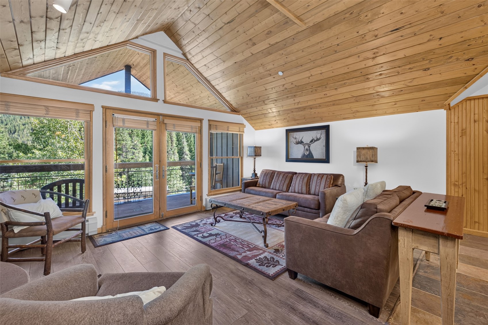 129 River Run Road, Unit 8051 Keystone, CO 80435 - Photo 10 of 50 Sloped wood-finish plank ceiling, wood-finish flooring, white walls, and wood-framed glass doors leading to an exterior balcony