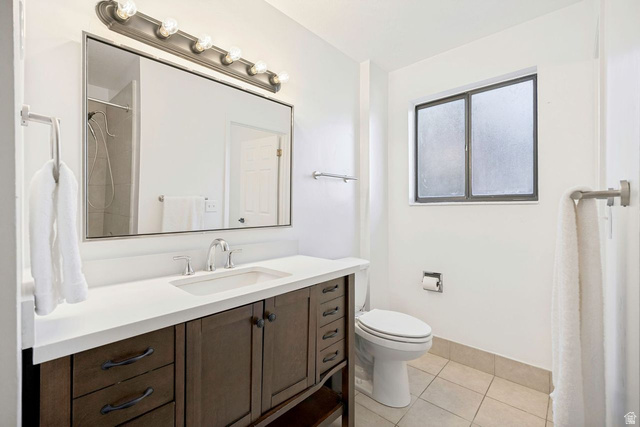 1723 Albury Road Sandy, UT 84092 - Photo 14 of 23 Bathroom featuring a dark wood-finish vanity with a white countertop and integrated sink, a rectangular mirror, and a multi-bulb vanity light fixture