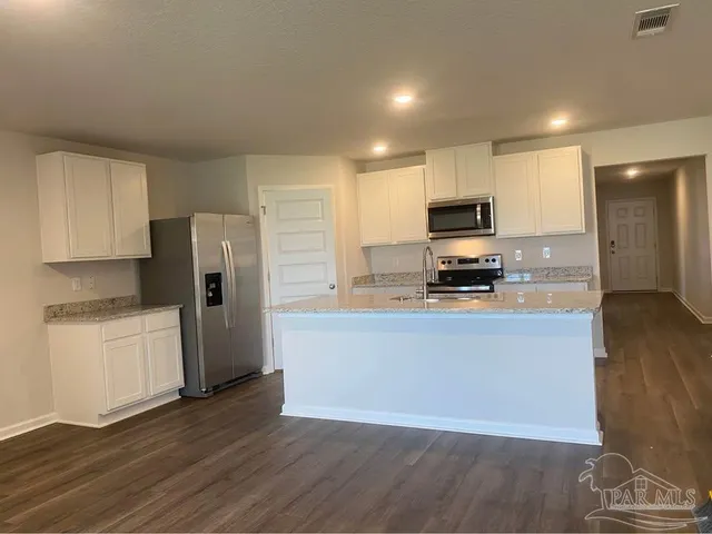 a kitchen with stainless steel appliances a refrigerator a stove top oven a sink and dishwasher