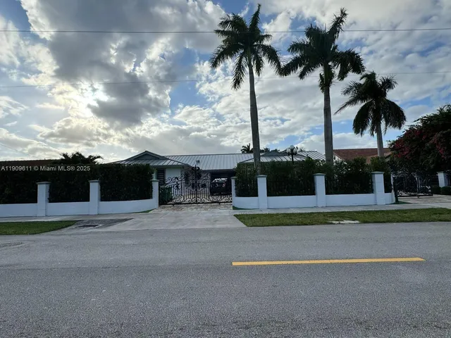 a front view of multiple houses with palm trees
