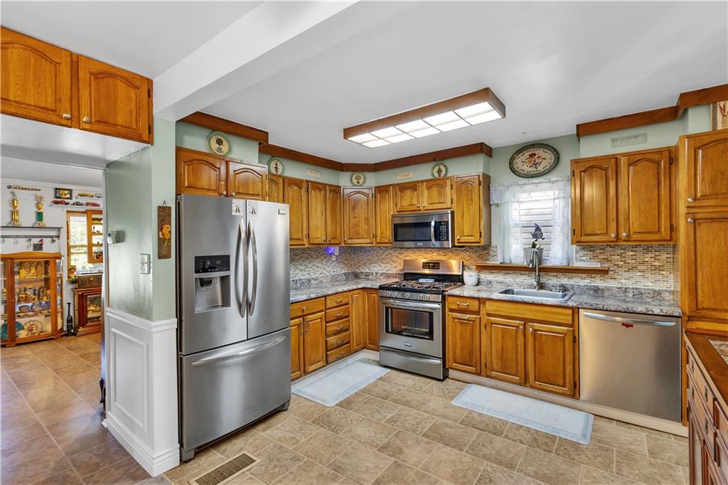 213 Whittier Street Vandergrift, PA 15690 - Photo 11 of 37 a kitchen with stainless steel appliances granite countertop a refrigerator a stove top oven a sink and dishwasher