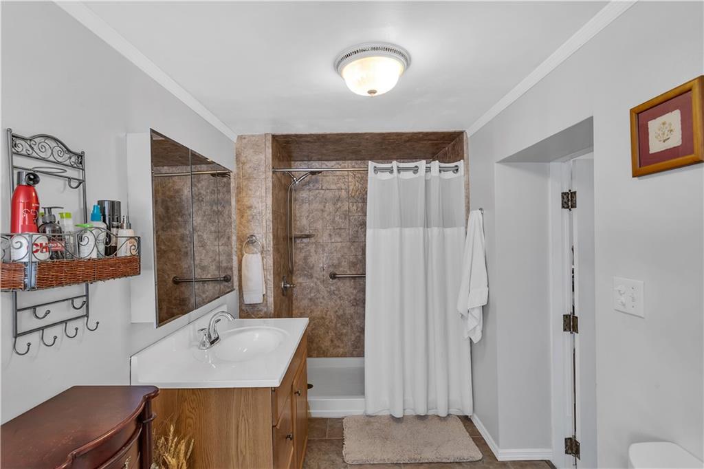213 Whittier Street Vandergrift, PA 15690 - Photo 19 of 37 a bathroom with a granite countertop sink a mirror and a shower