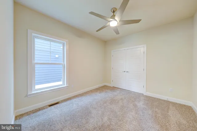 an empty room with a window and a fan