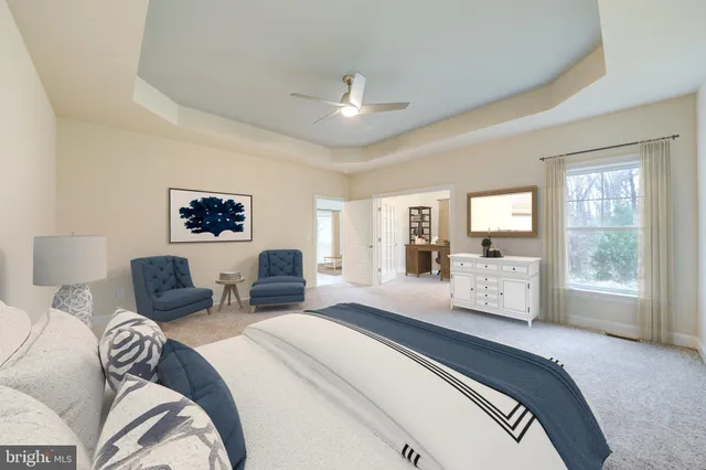 a spacious bedroom with a bed a couch and large window