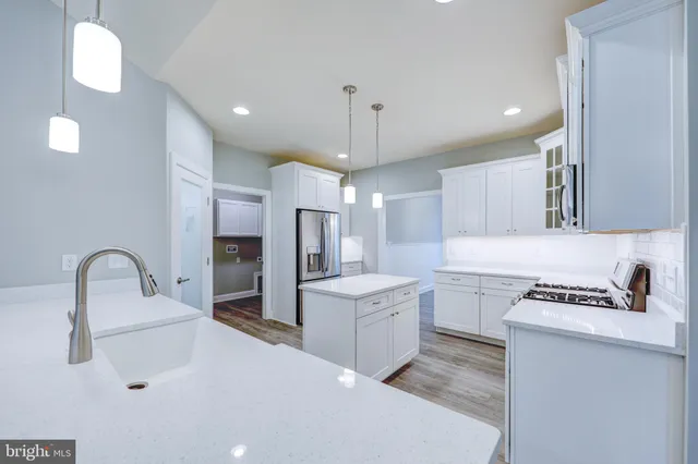 a kitchen that has a lot of cabinets in it and wooden floors