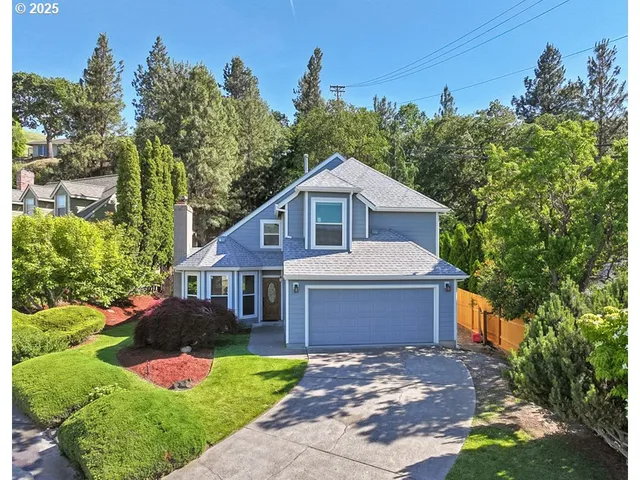 a front view of a house with a yard and potted plants