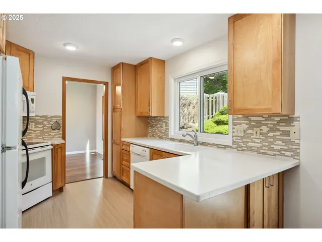 a kitchen with stainless steel appliances granite countertop a sink and a refrigerator