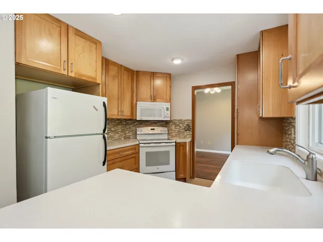 a kitchen with granite countertop a refrigerator stove and sink