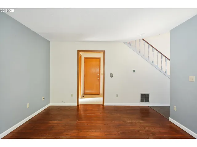 a view of an empty room with wooden floor