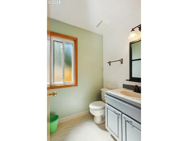 a bathroom with a toilet a sink and mirror