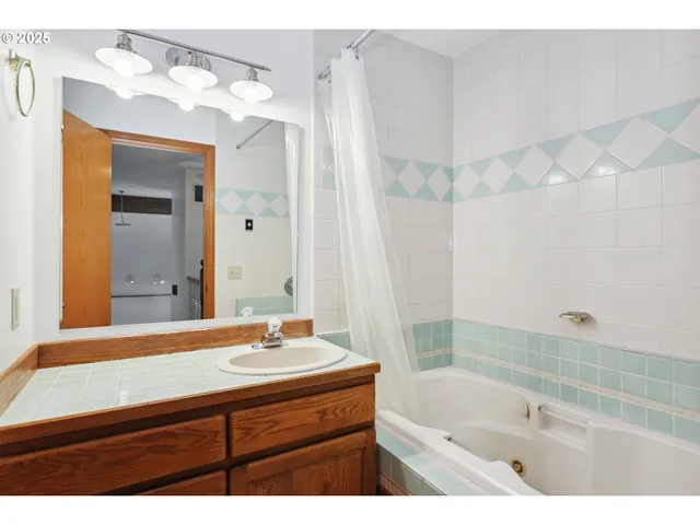 a bathroom with a sink vanity granite tub and a mirror